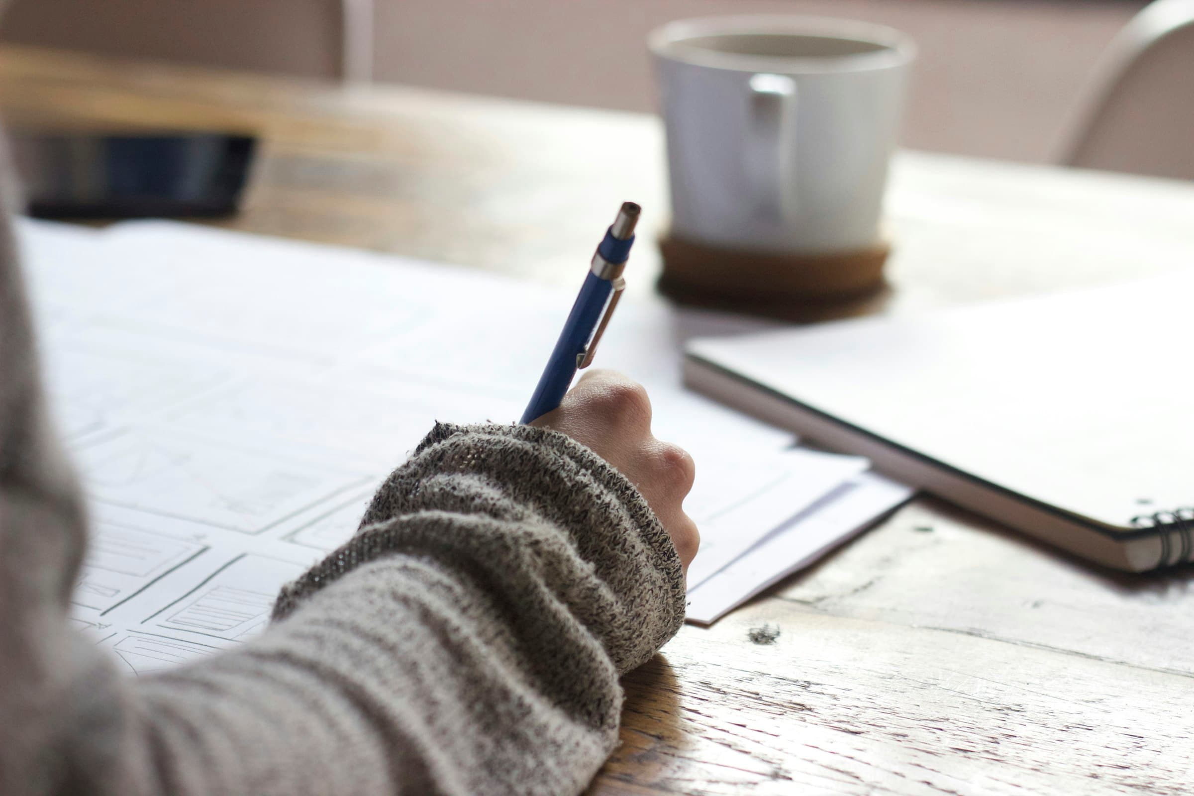 A focused adult learner studying and writing notes